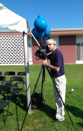 Videographer Denis Sweeney with camera recording a client's special event