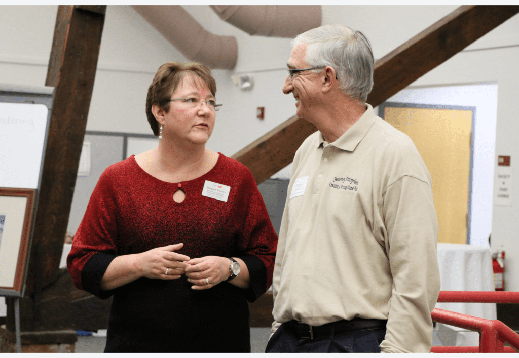 Denis Sweeney, Sweeney Enterprises LLC small business marketing consultant (right) talks with a fellow public relations practitioner (left) at a community event.